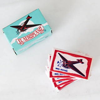 Foto cenital del colorante el aeroplano con unos sobres expuestos por fuera de su caja. Real Fábrica.