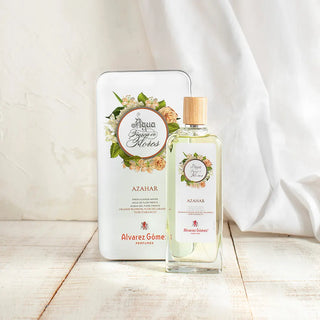 Foto de agua fresca de azahar Álvarez Gómez con frasco de vidrio con líquido blanco y caja con diseño de flores. Real Fábrica.