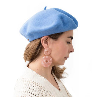 Foto de mujer de perfil luciendo nuestra boina de lana merino azul- Real Fábrica 