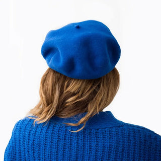 Foto de mujer de espalda luciendo nuestra boina de lana merino azulón- Real Fábrica 