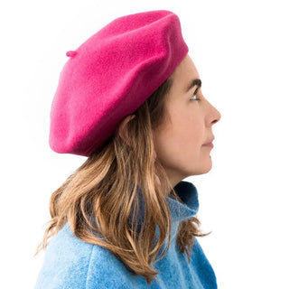 Foto de mujer de perfil luciendo nuestra boina de lana merino frambuesa- Real Fábrica 