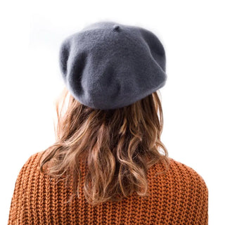 Foto de mujer de espalda llevando nuestra  boina de lana merino gris. Real Fábrica