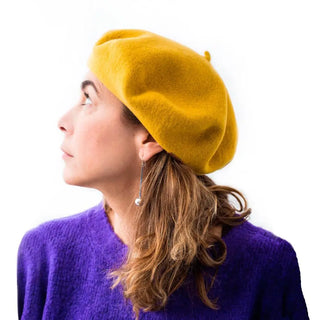 Foto de mujer luciendo nuestra boina de lana merino mostaza. Real Fábrica