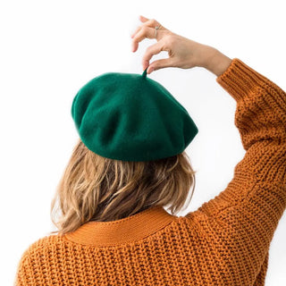 Foto de mujer de espalda luciendo nuestra boina de lana merino verde oscuro-Real Fábrica 