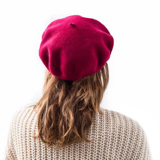 Foto de mujer de espalda luciendo nuestra boina de lana merino vino. Real Fábrica