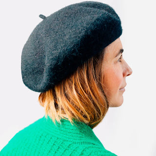 Foto de mujer luciendo nuestra boina de lana merino negra. Real Fábrica