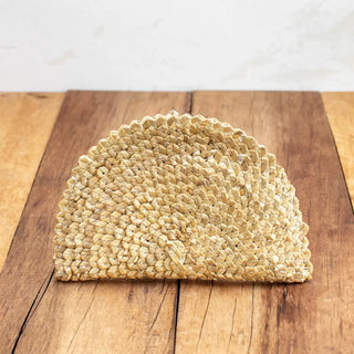 Bolso clutch de centeno en forma de abanico sobre una mesa de madera. Real Fábrica