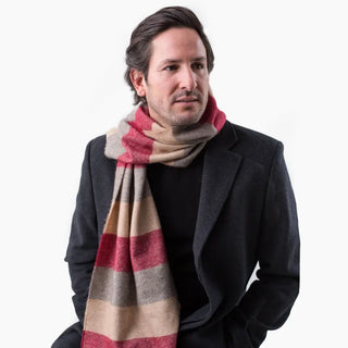 Foto de modelo luciendo nuestra bufanda de rayas burdeos. Es de lana merino, un tejido de alta calidad, suave, fino y transpirable.  Real Fábrica.