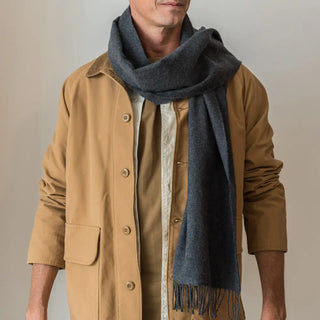 Foto de hombre luciendo nuestra bufanda de lana merino de color gris oscuro. Real Fábrica