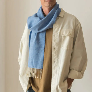 Foto de hombre luciendo nuestra bufanda de lana merino de color azul francia. Real Fábrica