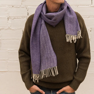 Foto de hombre luciendo nuestra bufanda de lana merino de color violeta. Real Fábrica