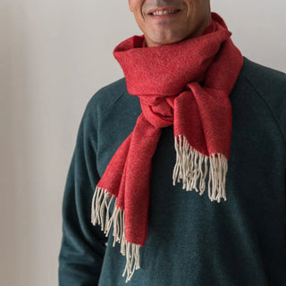 Foto de hombre luciendo nuestra bufanda de lana merino de color roja. Real Fábrica