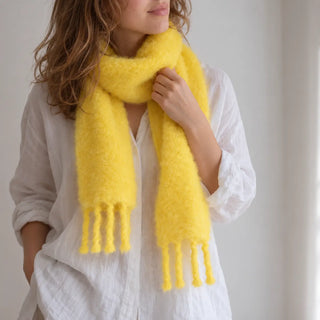 Mujer con bufanda chal de mohair amarilla con flecos. Real Fábrica