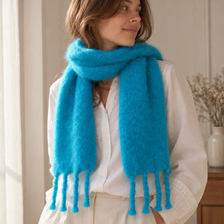 Mujer con bufanda chal de mohair azul cielo con flecos. Real Fábrica.
