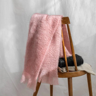 Una bufanda de mohair, suave, cálida y ligera, expuesta sobre una silla. Está hecho a mano por los artesanos riojanos de Ezcaray. Real Fábrica.