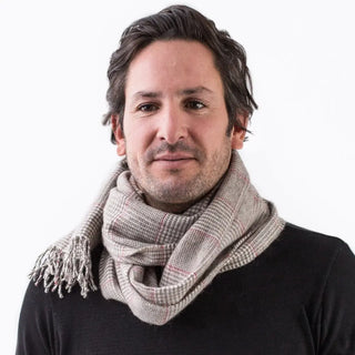 Hombre luciendo nuestra bufanda de príncipe de gales roja confeccionada en lana merino de la mejor calidad, de las ovejas de la Sierra de Grazalema, en Cádiz. Real Fábrica.