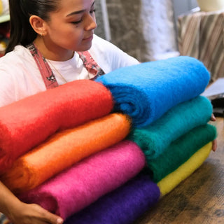 Mujer sujetando varias bufandas de mohair de Ezcaray en colores vivos