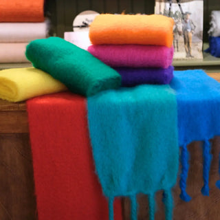 Bufandas de mohair de Ezcaray en distintos colores sobre el mostrador
