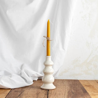 Foto de Candelabro con moldura de color blanco con una vela de cera. Es una pieza artesanal elaborada en Huelva. Real Fábrica. 