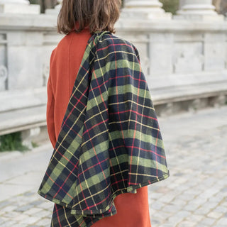 Foto de mujer llevando en uno de sus hombros nuestra Capa corta de Grazalema color escocesa. Real Fábrica