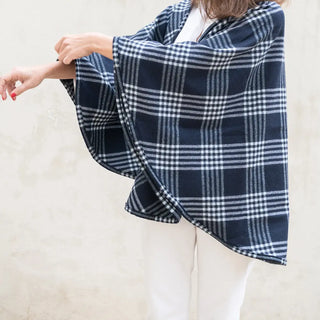 Foto de mujer luciendo nuestras capa de pura lana virgen de Grazalema, cuadros azules. Real Fábrica