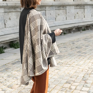 Foto de mujer llevando en su hombro nuestra Capa corta de Grazalema de cuadros. Real Fábrica