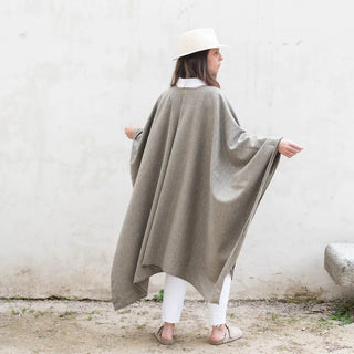 Foto de mujer de espalda llevando nuestra Capa larga de Grazalema de color caqui. Real Fábrica