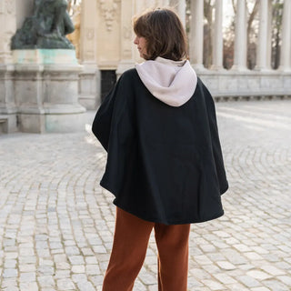 Foto de mujer de espalda luciendo nuestra capa corta color negra de lana merino de Grazalema. Real Fábrica