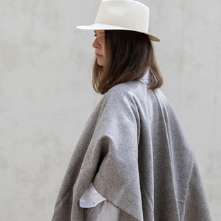 Foto de mujer luciendo muestra Capa ponchito de lana merino de color visón de Grazalema. Real Fábrica