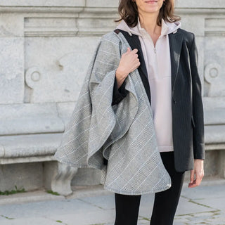 Foto de mujer llevando en uno de sus hombros nuestra Capa corta príncipe de gales de Grazalema. Real Fábrica
