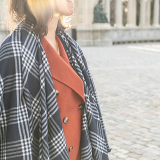 Foto de mujer de perfil mostrando Nuestras Capas de lana merino elaboradas con productos de calidad y manos ¡Artesanas y estilosas!. Real Fábrica