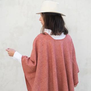 Foto de mujer llevando nuestra Capa ponchito de Grazalema de color arcilla. Real Fábrica