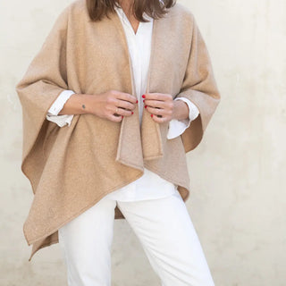 Foto de mujer mostrando nuestra Capa ponchito de Grazalema de color beige. Real Fábrica