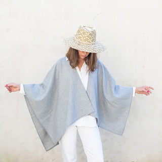 Foto de mujer luciendo muestra Capa ponchito gris claro de Grazalema. Real Fábrica