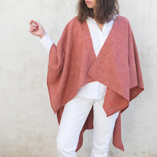 Foto de mujer luciendo muestra Capa ponchito de lana merino, color arcilla de Grazalema. Real Fábrica