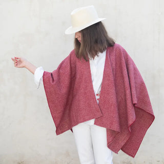 Foto de mujer luciendo nuestra Capa ponchito de lana merino color burdeos. Real Fábrica
