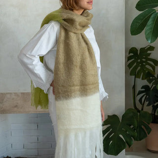 Mujer envuelta en un chal bufanda de mohair en 3 colores: camel, mostaza y crudo. El tejido artesano es de gran calidad, suave y muy cálido. Real Fábrica.