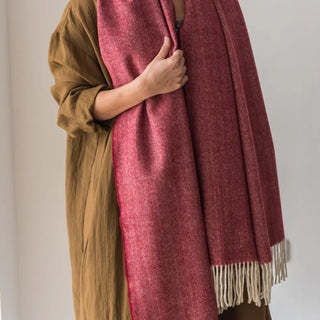 Mujer luciendo los dos extremos de un Chal de lana merino de Grazalema, con su tradicional acabado en flecos artesanos, es decir, que se anudan uno a uno y a mano. Real Fábrica.