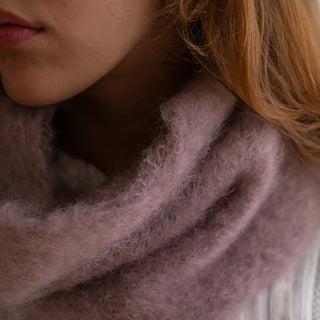 Plano detalle de un cuello de mohair en color violeta rosado. Se aprecia la calidad y la textura del mohair tejido a mano. Real Fábrica.