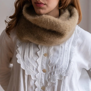 Mujer posa con un cuello de mohair en tono cobre. Es esponjoso, cálido y muy suave. Real Fábrica.