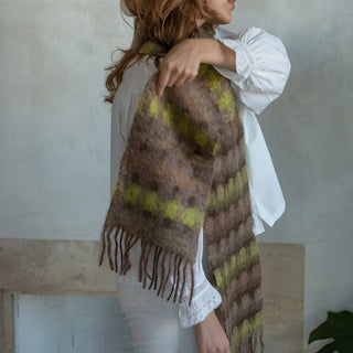 Foto de mujer abrigada con un suave y cálido foulard de cuadros marrón y amarillo. Real Fábrica.
