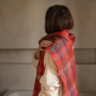 Mujer de perfil luciendo un foulard de mohair, suave, cálido y ligero. Está hecho a mano por los artesanos riojanos de Ezcaray. Real Fábrica.