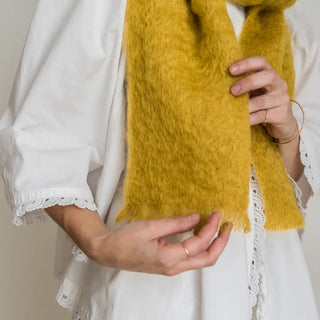 Mujer con un foulard de mohair amarillo, tejido a mano por los artesanos de Ezcaray. Real Fábrica.
