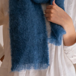 Detalle del remate en flecos finos de un foulard de mohair de color azul. El tejido artesano es de gran calidad, cálido y suave. Real Fábrica.