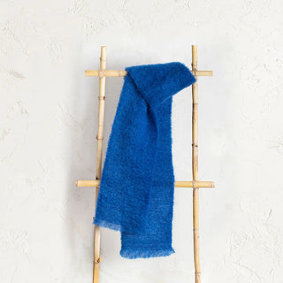  Un foulard de mohair color azul klein expuesto en una escalera de madera vintage, una fibra de origen natural ultra cálida y ligera, de gran calidad. Real Fábrica.  