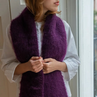Foto de Mujer abrigada con un foulard de mohair en color berenjena oscuro, suave y muy cálido. Real Fábrica.