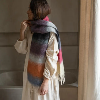 Modelo mostrando un foulard de franjas de Ezcaray con terminación en flecos gruesos. Los flecos están elaborados a mano. Real Fábrica.