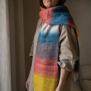 Modelo mostrando un foulard de Ezcaray con terminación en flecos gruesos. Los flecos están elaborados a mano. Real Fábrica.