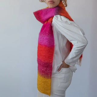 Mujer abrigada con un foulard de mohair de franjas, una fibra de origen natural ultra cálida y ligera, de gran calidad. Real Fábrica. 