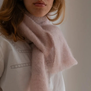 Mujer con foulard de mohair anudado al cuello. En este primer plano se aprecia la calidad y la textura del mohair. Real Fábrica.